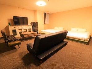 A hotel room with a bed, a sofa, a desk, a television, and a wardrobe. - A-Gate Hotel (Hakodate)