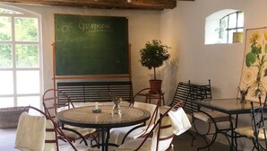 A rustic dining area with wooden furniture, a chalkboard, and a potted plant. - Villa Sandby Bed and Breakfast (Borrby)