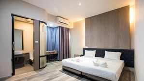 A modern hotel room with a large bed, a desk, and a bathroom. - Tara Park Resotel (Thanyaburi)