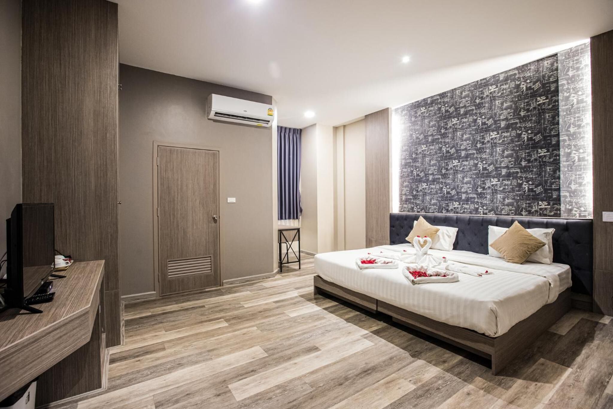 Una habitació d'hotel moderna amb un llit gran, un escriptori i un aparell d'aire condicionat.