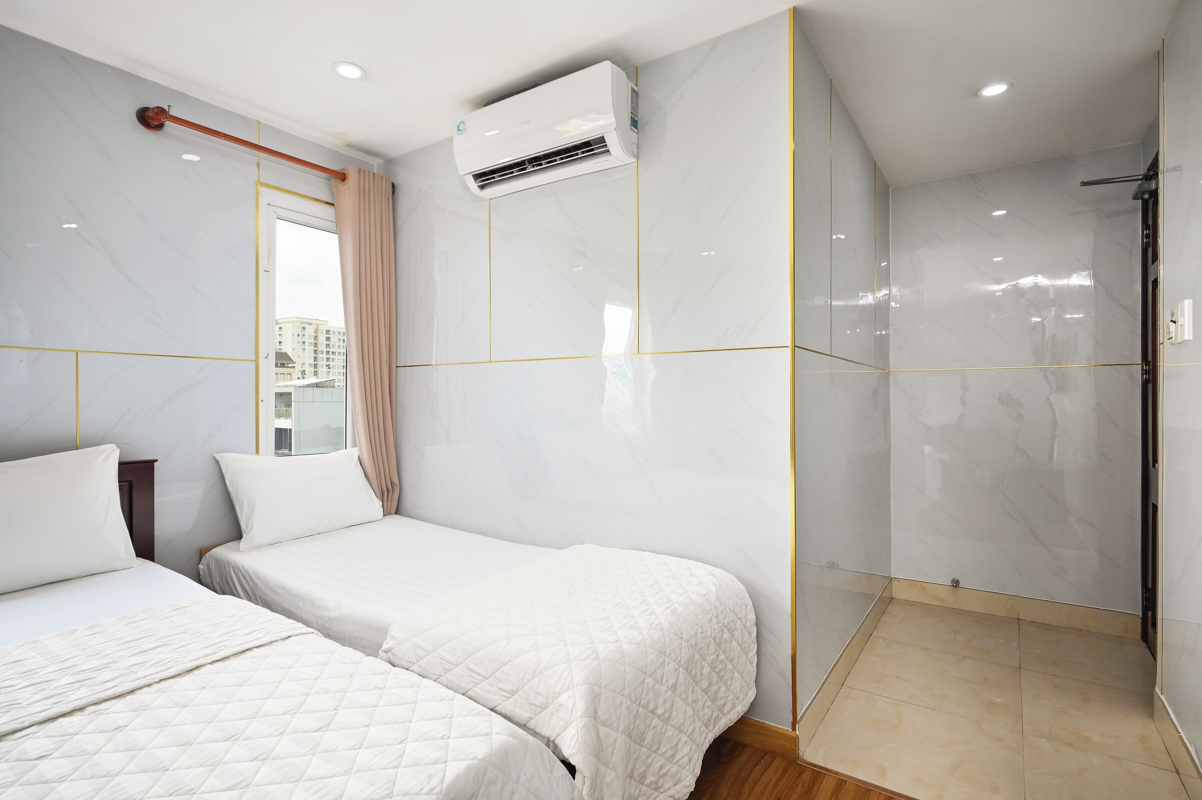 Ein Hotelzimmer mit zwei Betten, einer Dusche und einer Klimaanlage.