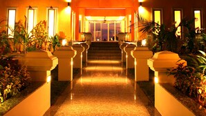 A hotel entrance with a traditional architectural style, featuring a prominent roof and a well-lit pathway leading to the entrance. - Peninsula Beach Resort (Ko Chang)