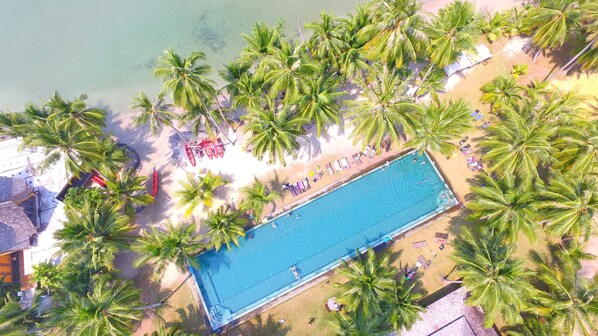 An aerial view of a beach with a swimming pool surrounded by palm trees. - Peninsula Beach Resort (Ko Chang)