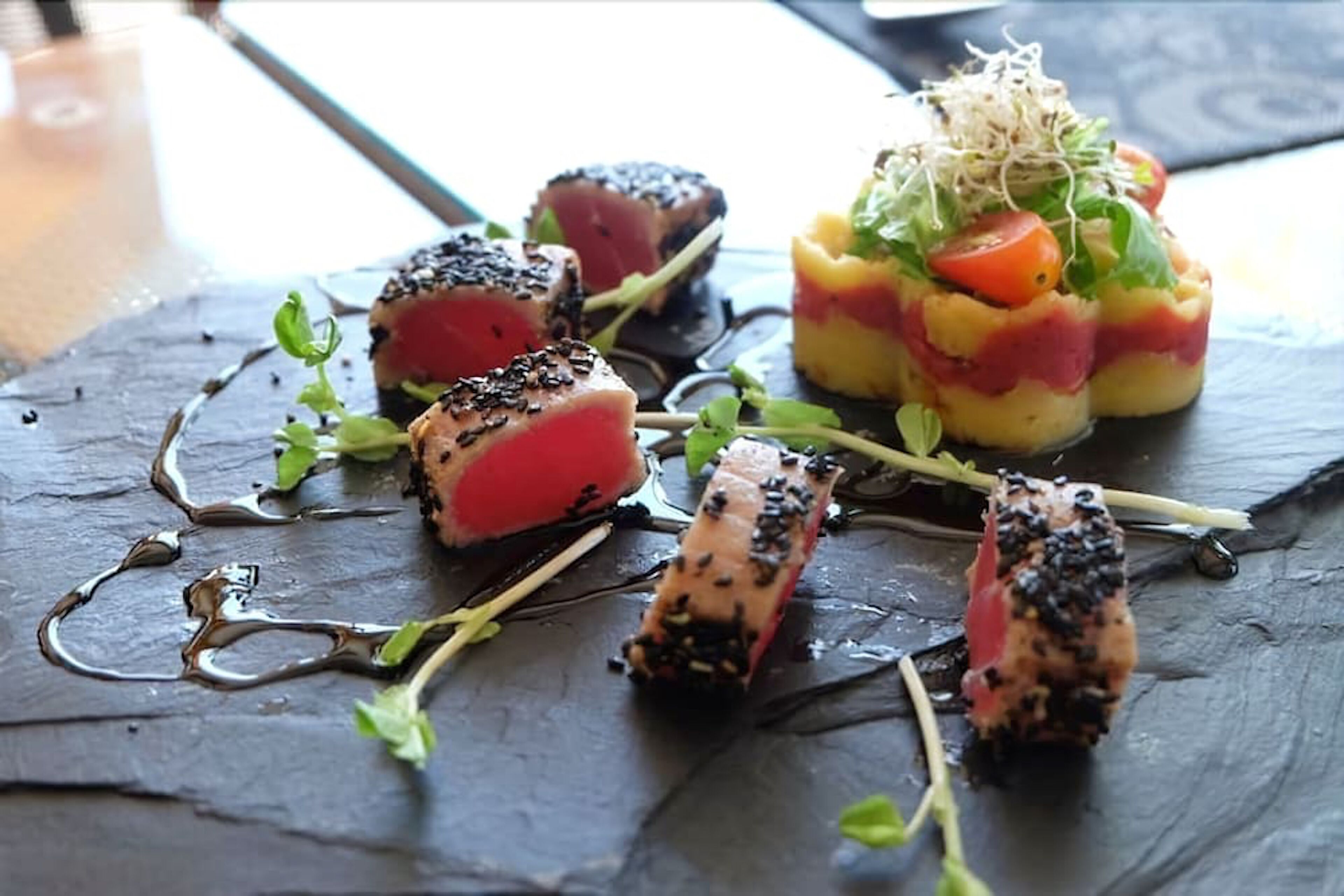 A variety of sushi dishes on a slate plate.