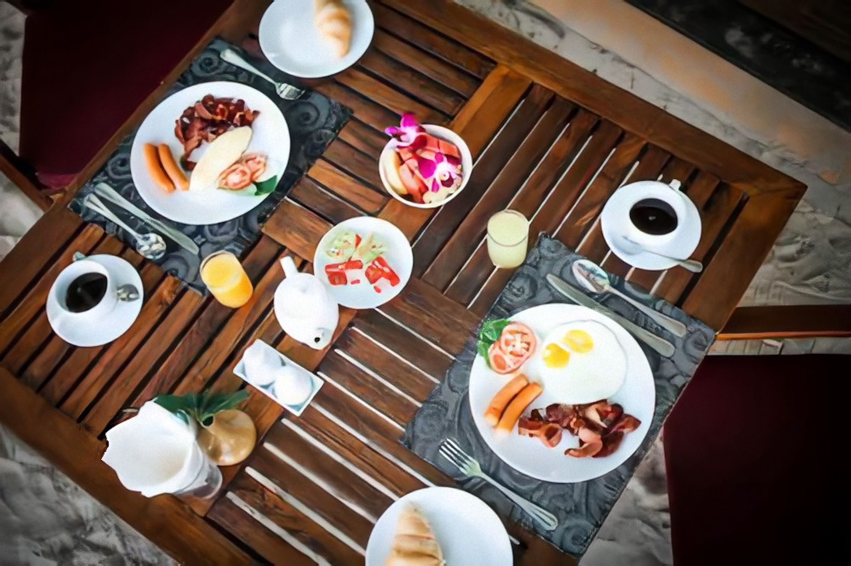 Un desayuno con platos de huevos, tocino y tostadas, además de un bol de fruta y una taza de café.