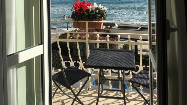 A balcony with a view of the sea, a potted plant, and outdoor furniture. - Hotel Villa Igea (Alassio)