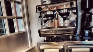 A breakfast setting with pastries and a cup of coffee, a keychain, and a coffee machine. - Hotel Villa Igea (Alassio)