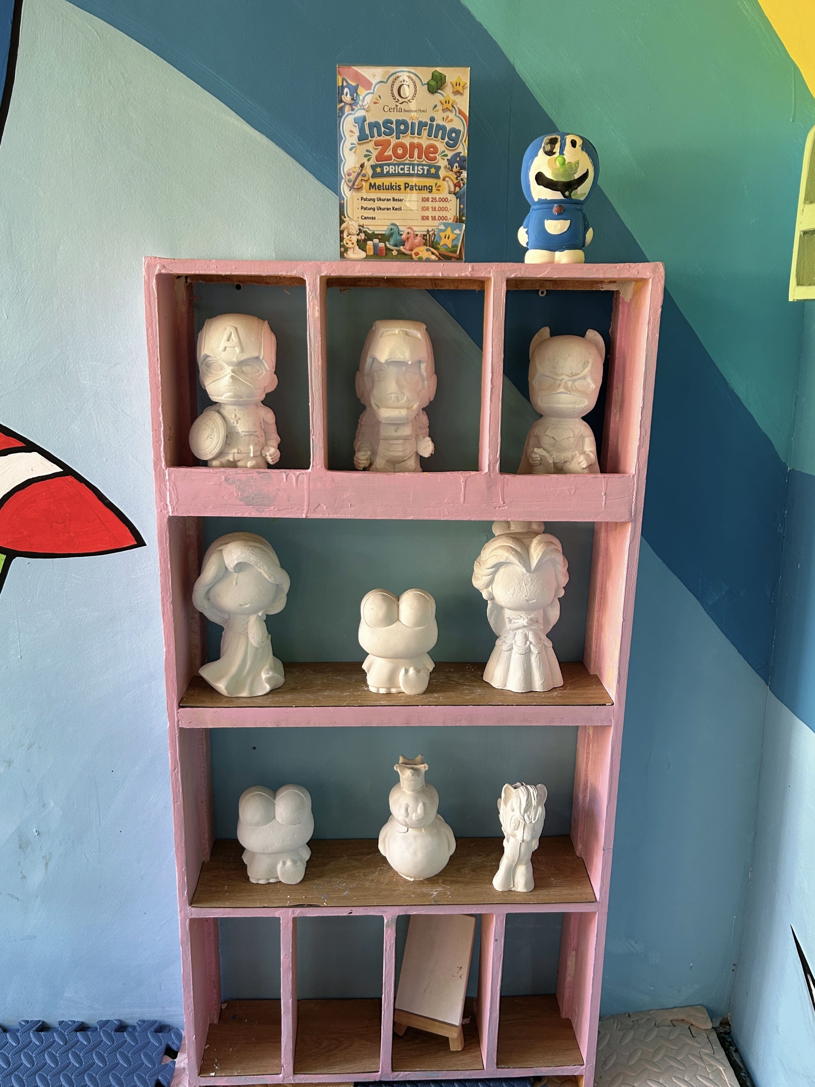 Una mensola con diverse figurine in ceramica e una scatola con l'etichetta 'Inspiring Zone'.