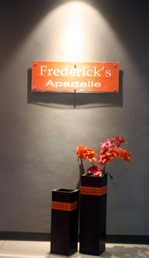 A sign reading "Frederick's Apartelle" above two vases with flowers. - Frederick's Apartelle (Mandaluyong)