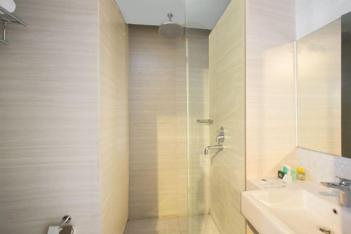 A modern bathroom with a shower, a sink, and a mirror.