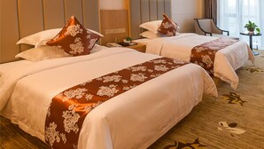 A hotel room with two beds, a desk, a chair, and a small table with a plant. - Hangzhou OUYAMEI International Hotel (Hangzhou)