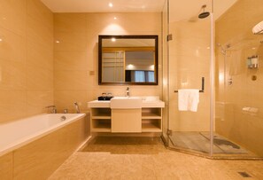 A modern bathroom with a bathtub, a sink, a mirror, and a glass-enclosed shower area.