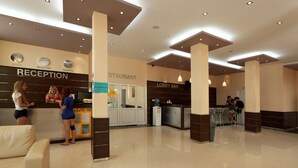 Ein Hotel mit Rezeption, einer Bar in der Lobby und einem Restaurant.