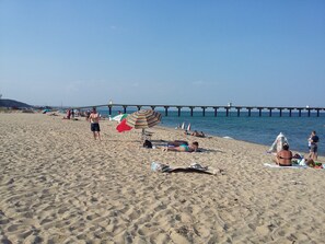 A sandy beach with a pier in the background. - Sea Dunes Complex (Dolni Chiflik)