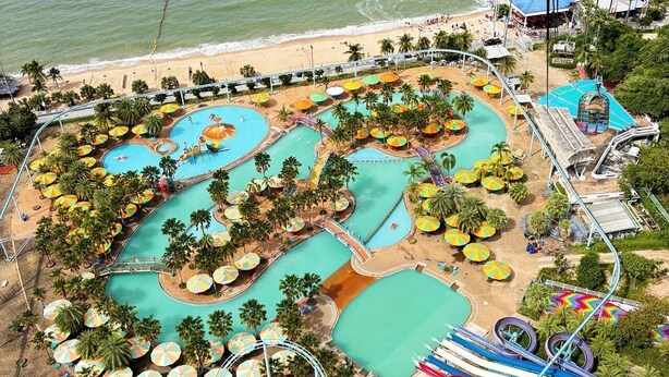 Um parque aquático com várias piscinas, toboáguas e uma área de praia.
