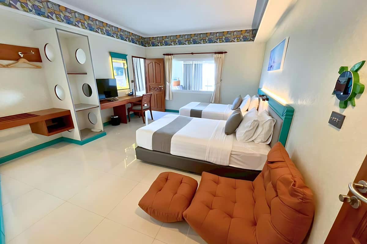 Une chambre d’hôtel comprenant un lit, un bureau, une chaise, une télévision et une salle de bain.