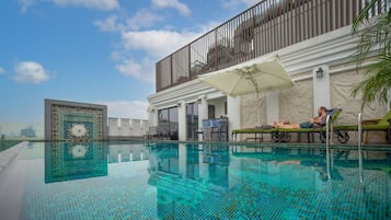 Een buitenzwembad en ligstoelen