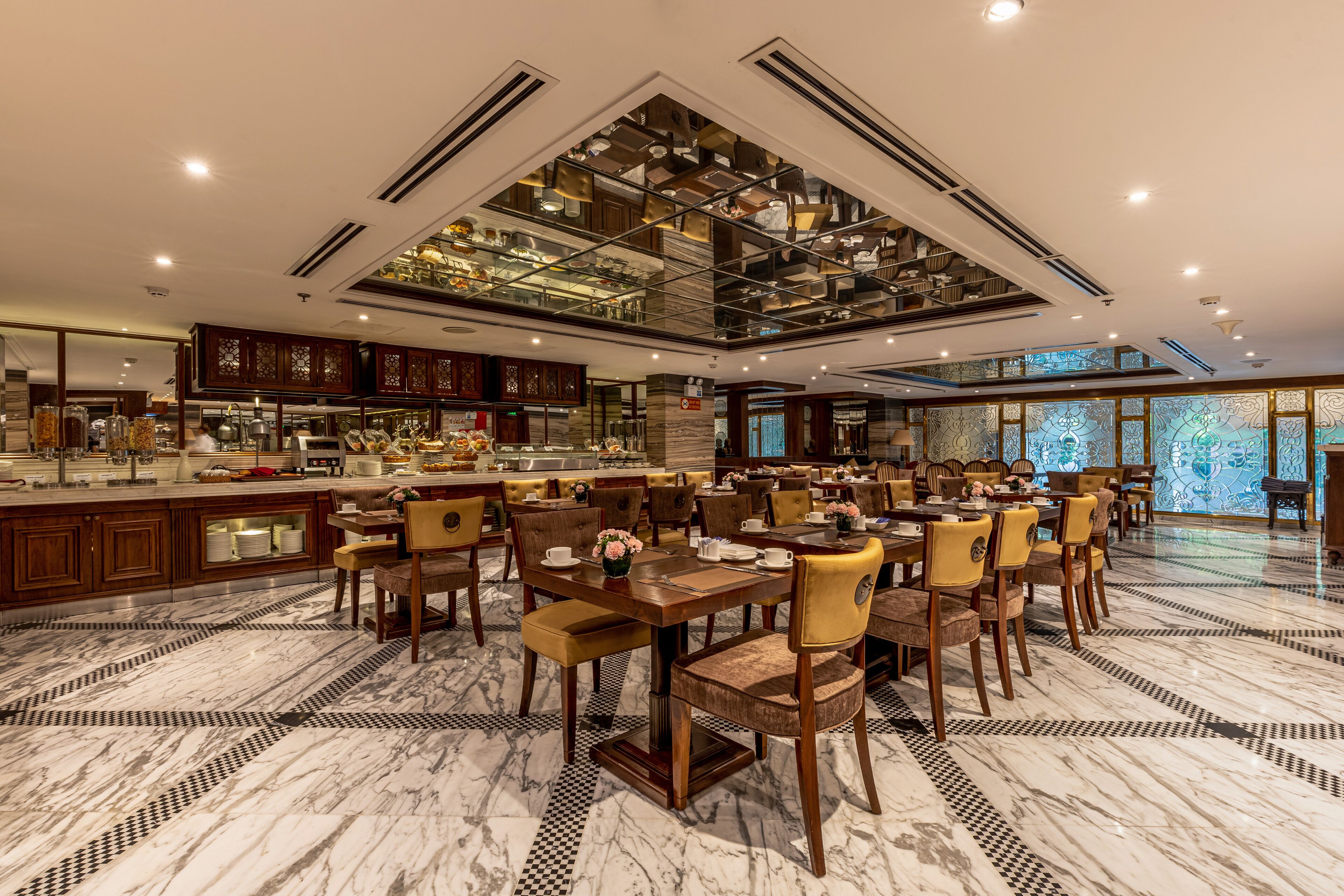 A spacious dining area with marble flooring and wooden furniture.