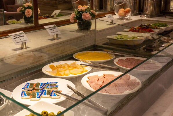 A buffet with various food items and a glass display case. - The Lapis Hotel (Hanoi)