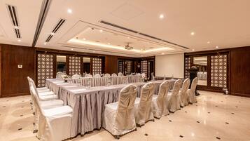 A conference room with a long table, chairs, and a projector screen.