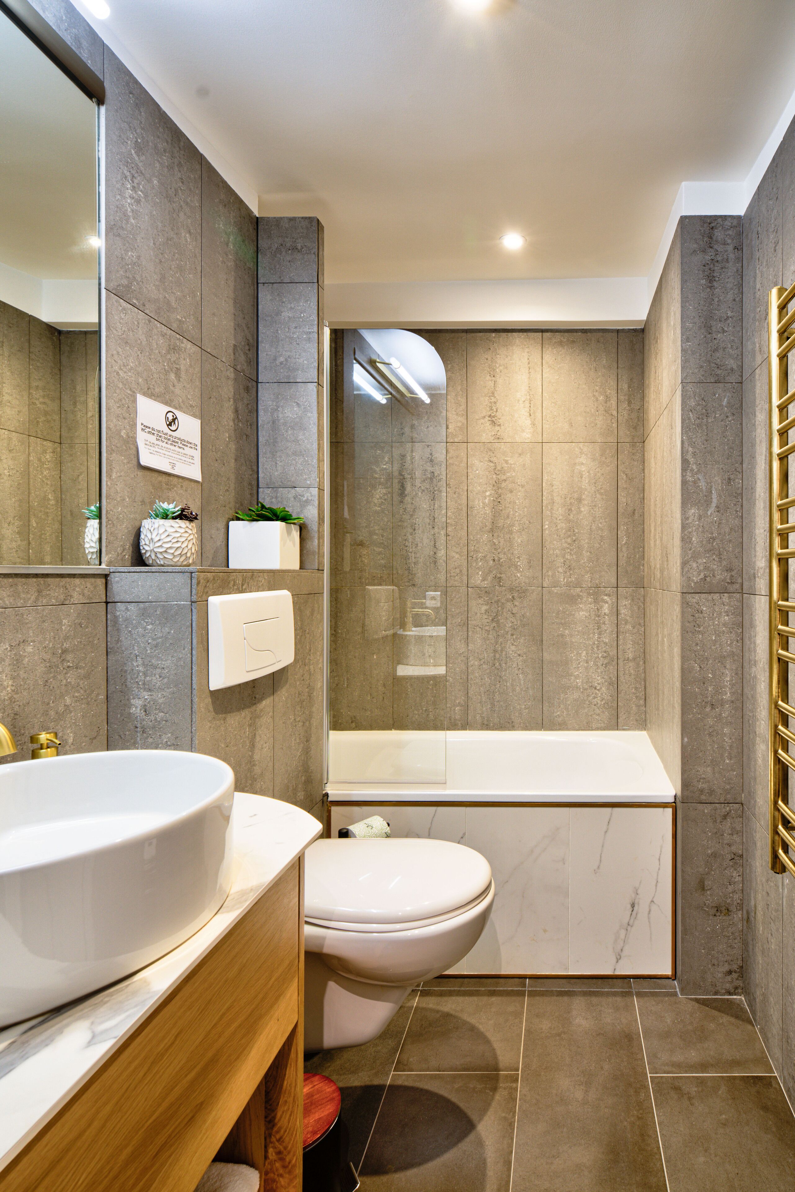 A modern bathroom with a large sink, toilet, and bathtub.