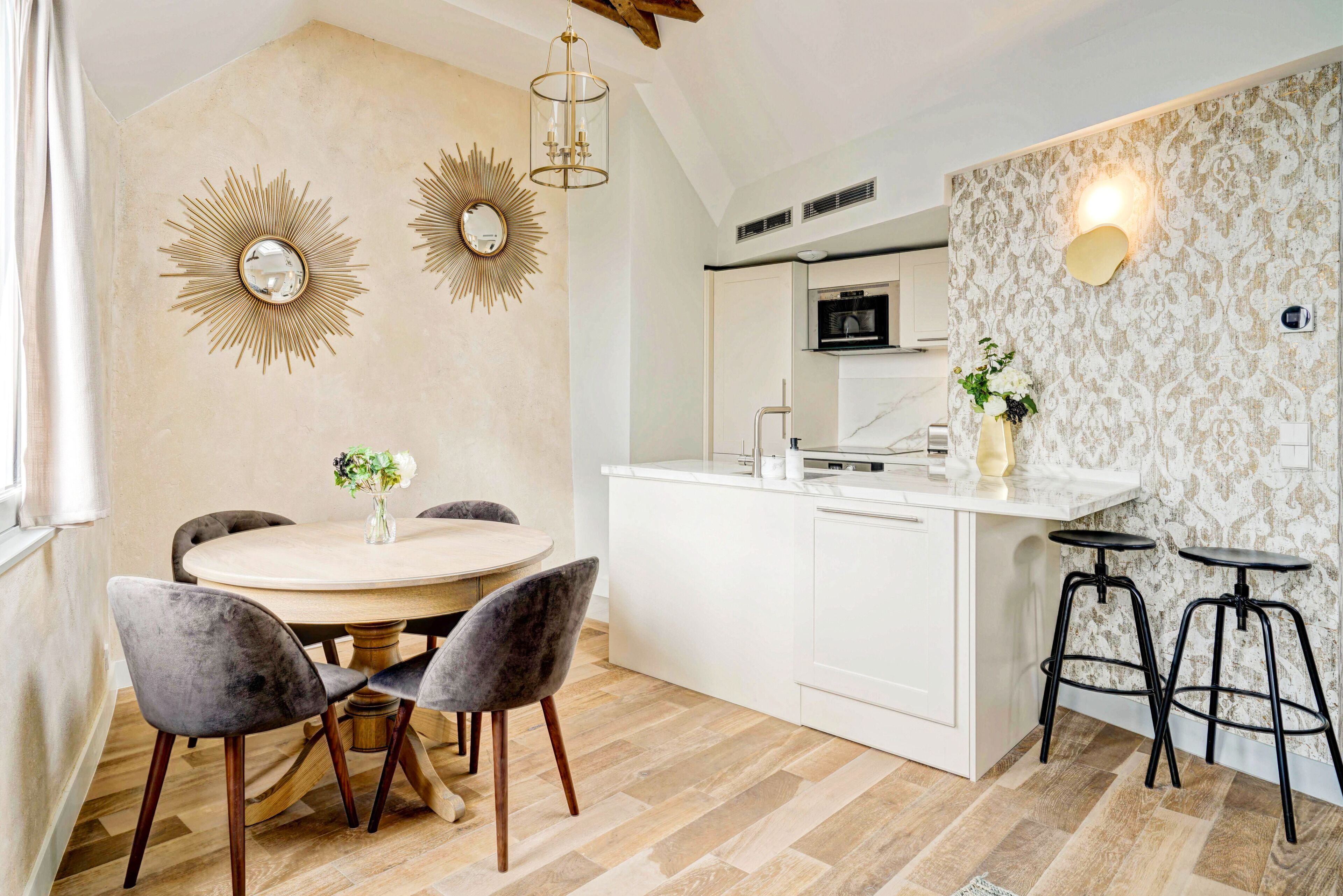 A modern kitchen with white cabinetry, a central island, and two bar stools.