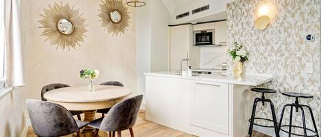 A modern kitchen with white cabinetry, a central island, and two bar stools.