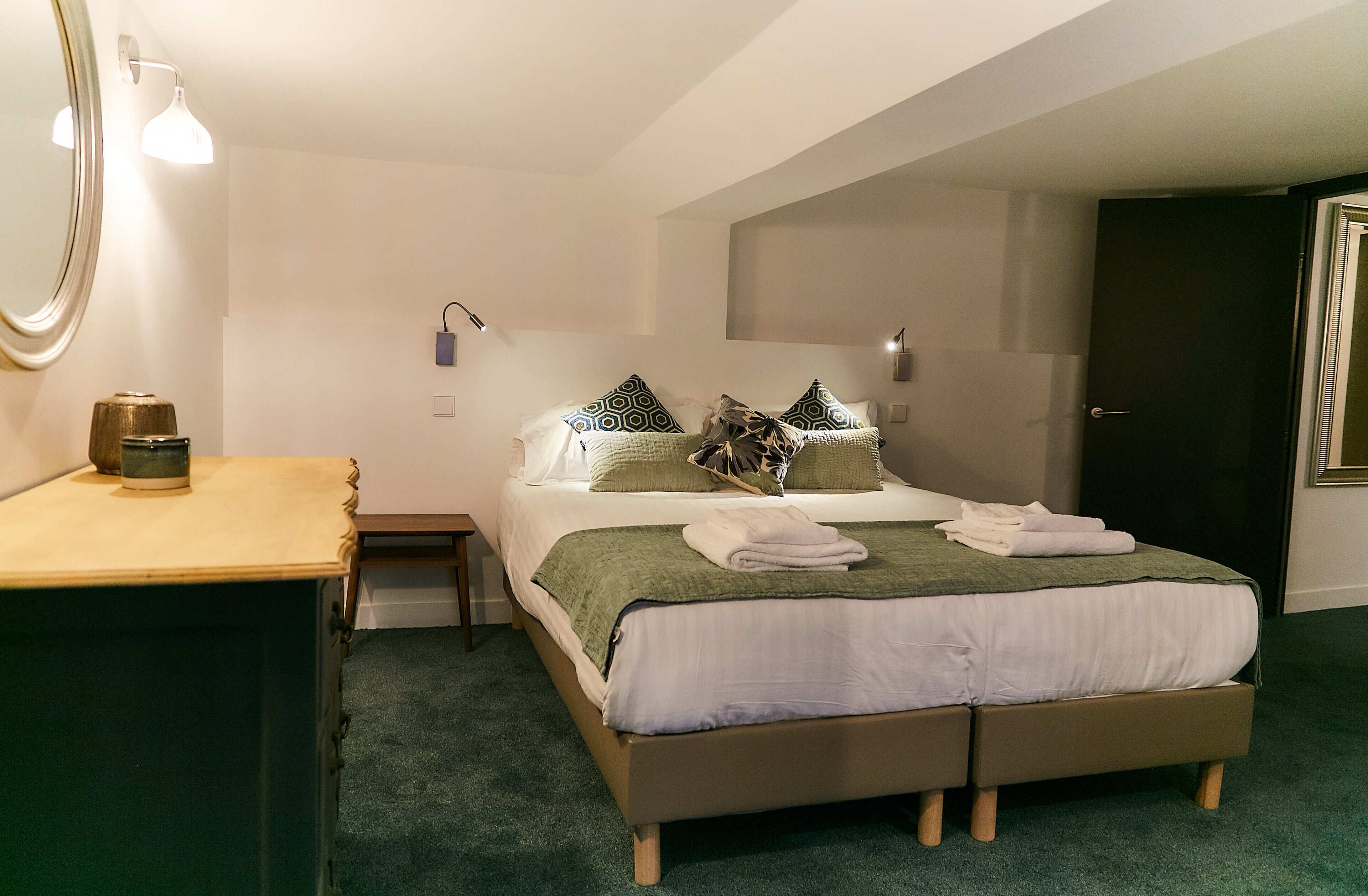 Ein ordentlich eingerichtetes Schlafzimmer mit Bett, Nachttischen und einem Kleiderschrank.