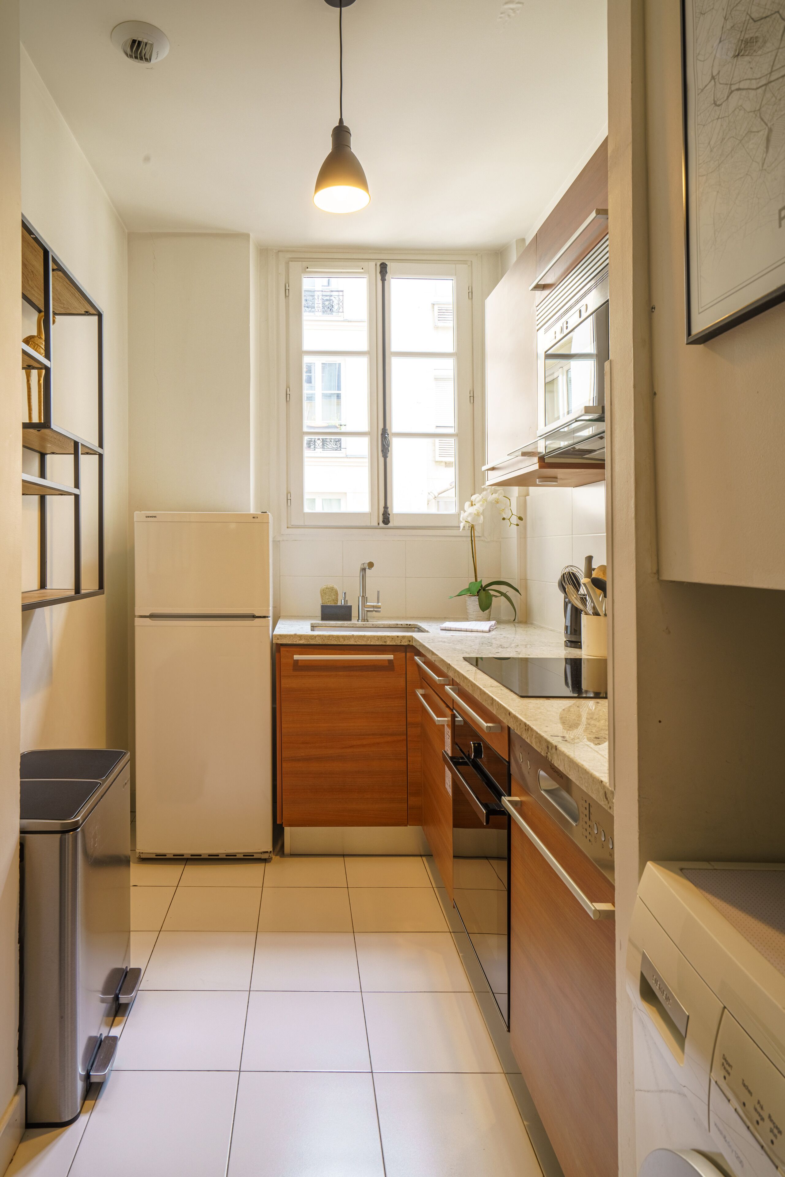 Una cucina moderna con frigorifero, lavello, pensili in legno e lavastoviglie.