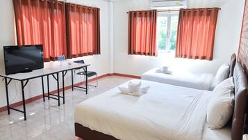 Une chambre d’hôtel avec deux lits, une télévision, un bureau et une fenêtre avec des rideaux.