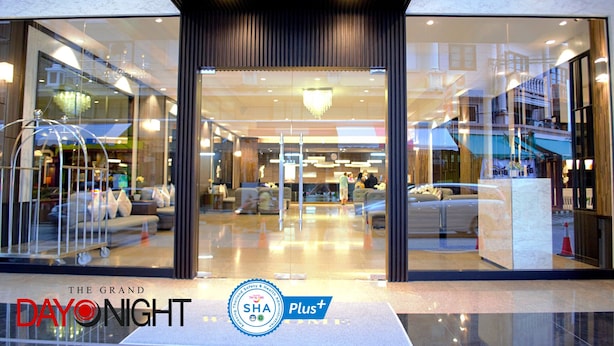 A hotel entrance with a modern design, glass doors, and a reception desk. - The Grand Day Night (Pattaya)