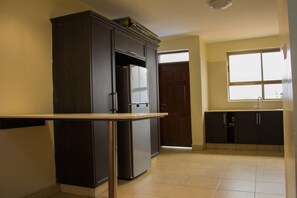 Departamento ejecutivo, 3 habitaciones | Cocina privada | Refrigerador, microondas, horno y cafetera y tetera 