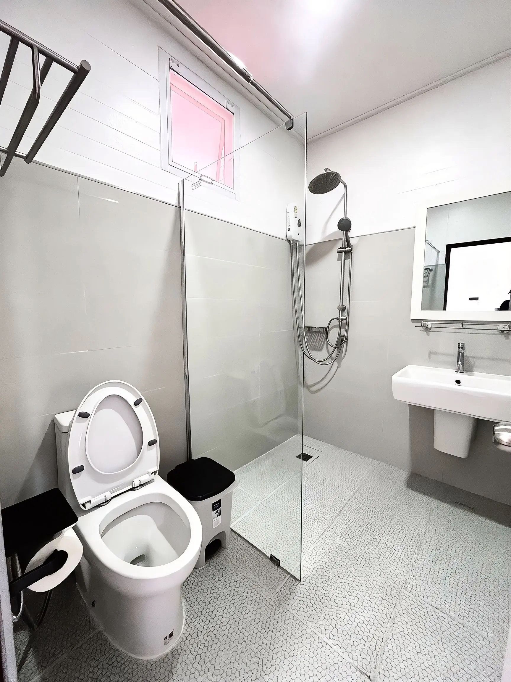 A small, modern bathroom with a toilet, a shower, and a sink.