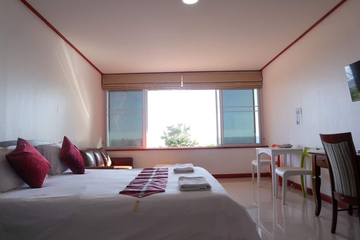 Une chambre d’hôtel avec un lit, un bureau et une chaise.