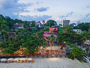 A beachfront property with multiple buildings, a sandy beach with lounge chairs, and palm trees. - Baansuan Aokhai Beach Resort (Klaeng)