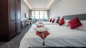Une chambre d’hôtel avec deux lits, un bureau et une télévision.