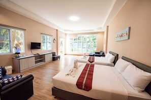 A hotel room with two beds, a desk, a television, and large windows. - Baansuan Aokhai Beach Resort (Klaeng)