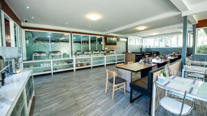 Un restaurant moderne doté d’un long comptoir, de plusieurs espaces de restauration et d’une grande fenêtre laissant entrer la lumière naturelle.