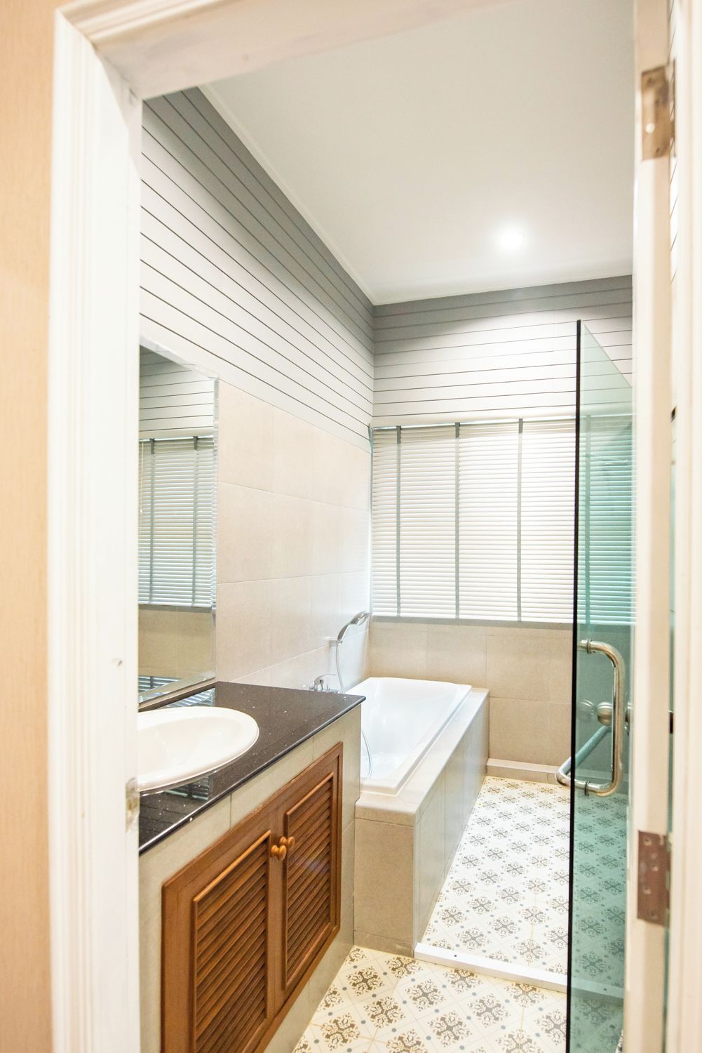 Une salle de bain équipée d’une baignoire, d’un lavabo et d’une douche à parois en verre.