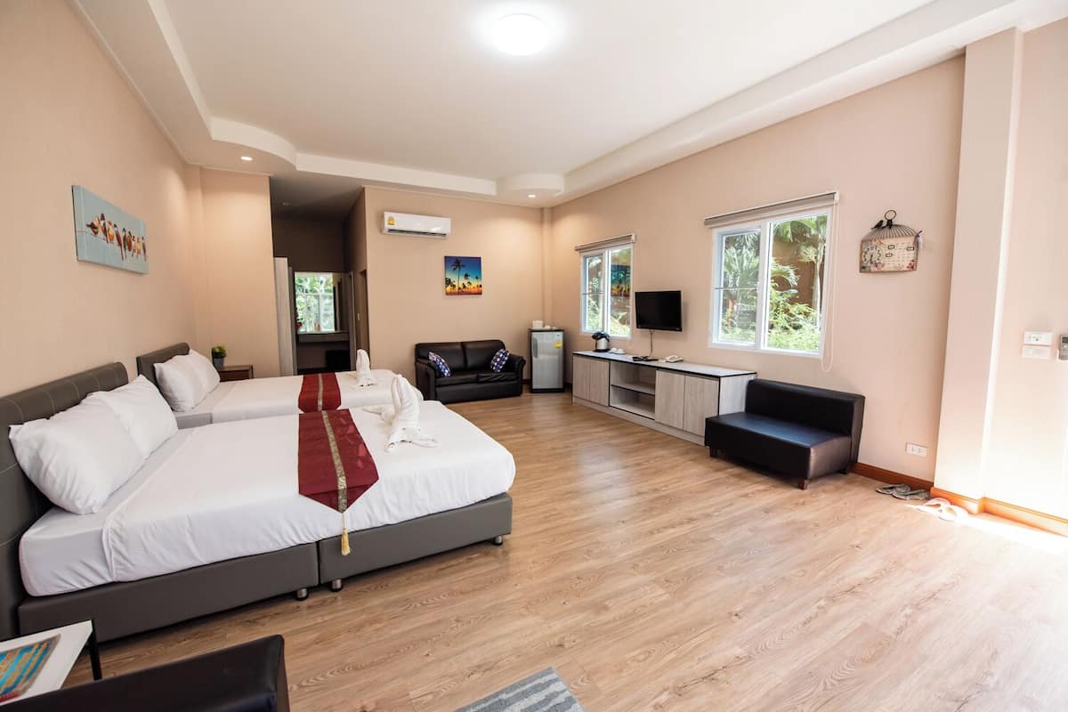 Une chambre d’hôtel avec un grand lit, un bureau, un canapé et une télévision.