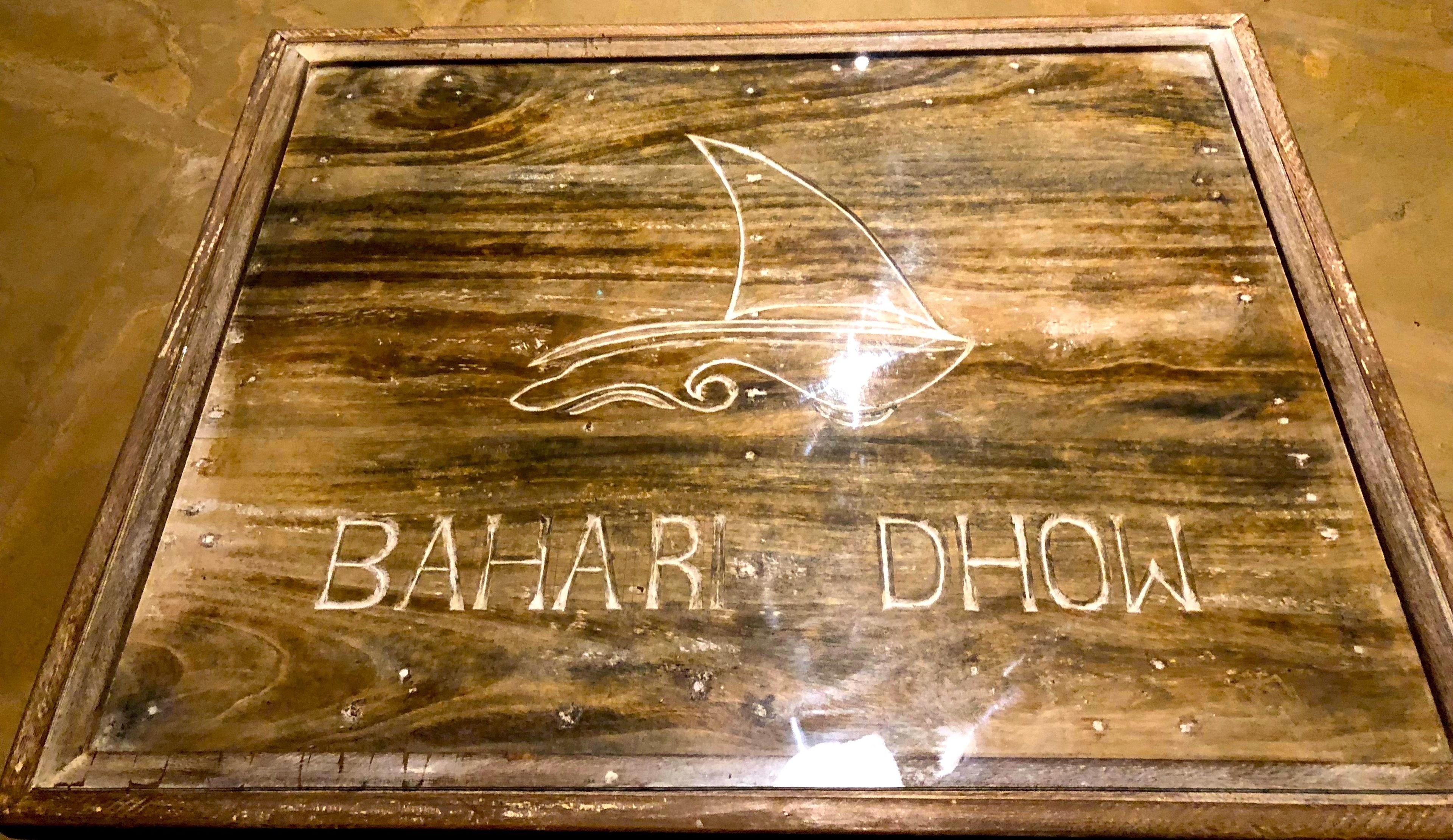 A wooden sign with a boat and the text "BAHAR DHOW".