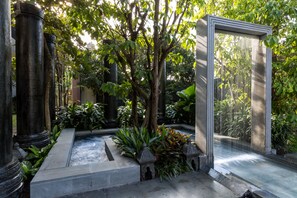 A serene courtyard with stone columns, a central water feature, and lush greenery. - Ung-D Hotel (Siem Reap)