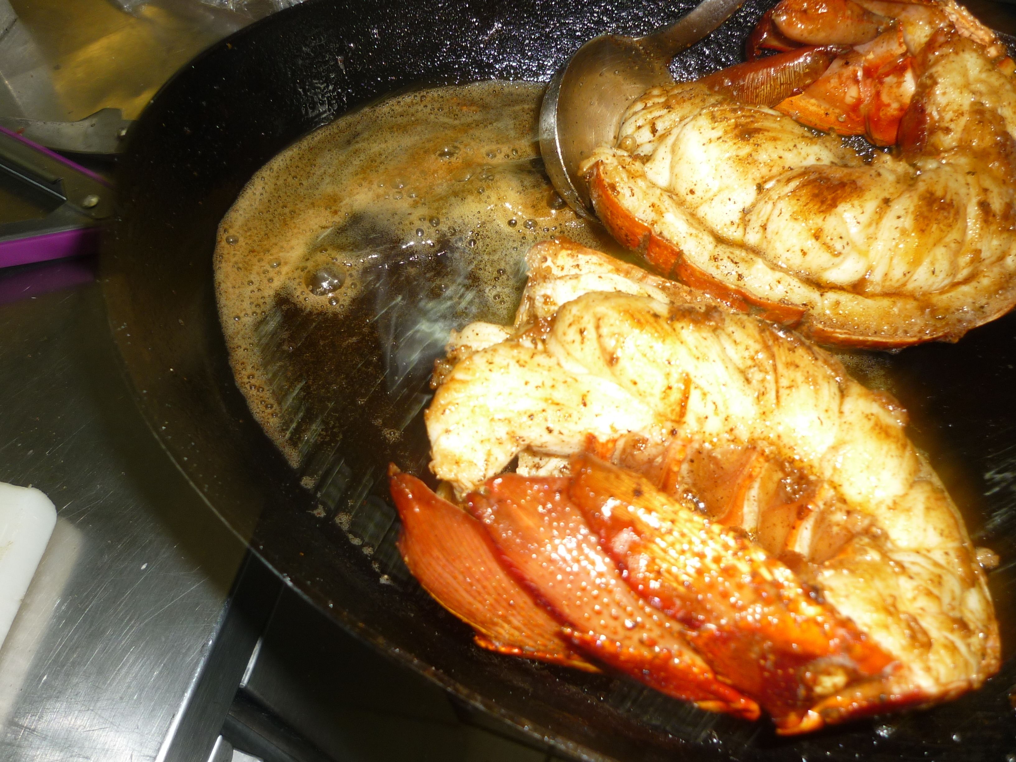 Une assiette contenant deux morceaux de poulet et une tomate.