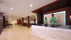 A spacious lobby with a reception desk, seating area, and a modern architectural design. - Paragon Suites Resort (Pattaya)