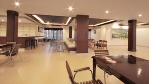 A spacious lobby with a reception desk, seating area, and large windows. - Paragon Suites Resort (Pattaya)