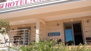 Un hotel llamado "HOTEL CORALLO" con un cartel sobre la entrada.
