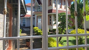 A two-story house with a red roof, white walls, and a balcony. - Villa Leone (Nairobi)