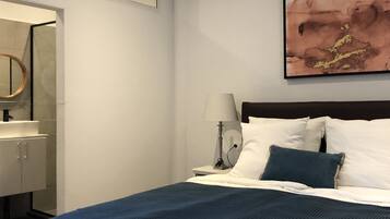 A hotel room with a bed, a nightstand, a lamp, a mirror, and a painting on the wall.