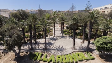 A landscaped area with palm trees and a pathway leading to a building with the name 'TARUMAL' visible.