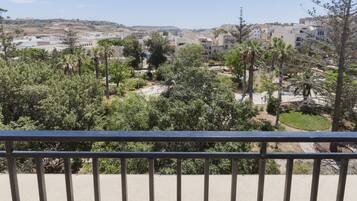 A balcony with a view of a residential area, including houses and greenery.